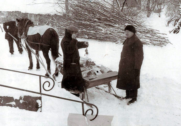 Januar Slagter Albert Weng, hvis forretning lå på Kirkebakken 22 (overfor Det gamle Mejeri) ses her i den hårde vinter, hvor han bringer varer ud til kunderne på hestetrukket slæde. Her vejer han kødet på sin bismervægt. Foto 1940-45 
