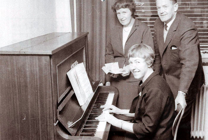Det er Ester Jacobsen ved  klaveret, omsorgsleder Ester Gisselmann stående og formand for socialudvalget Elvin Hansen. Foto 1967